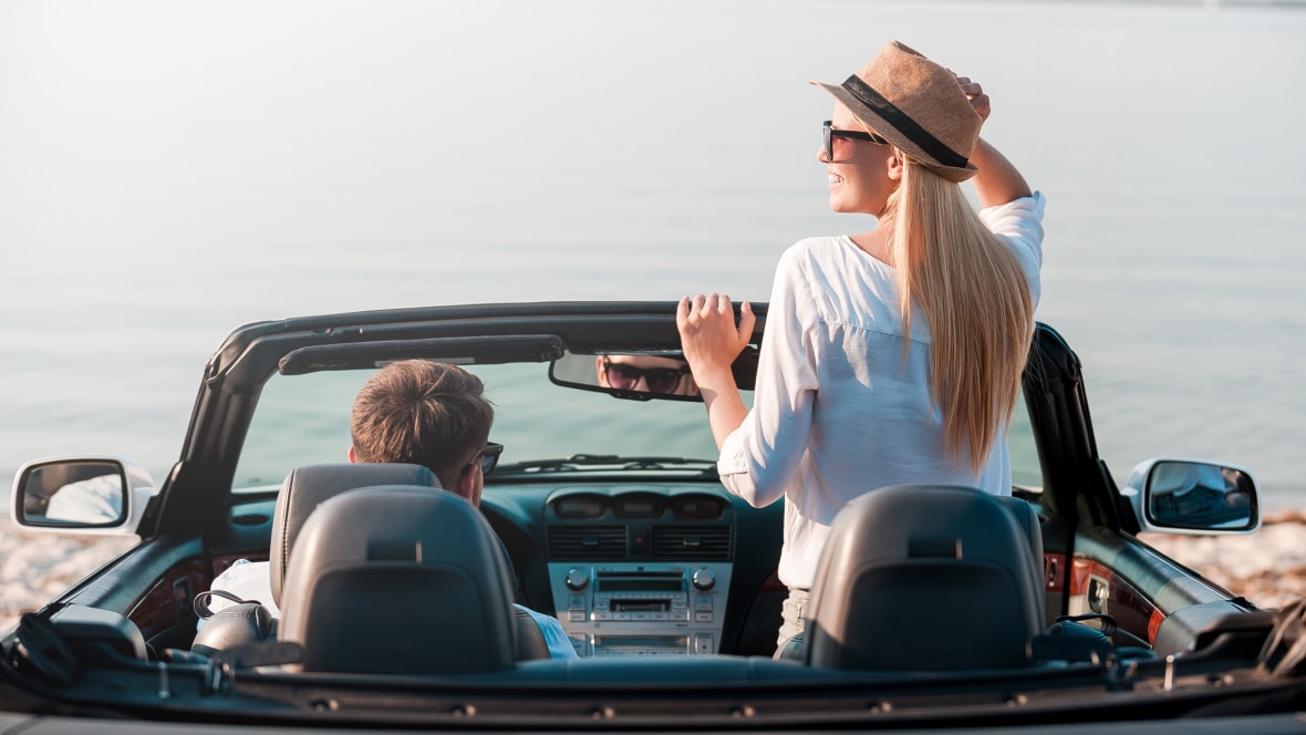 Men and women riding in a convertible